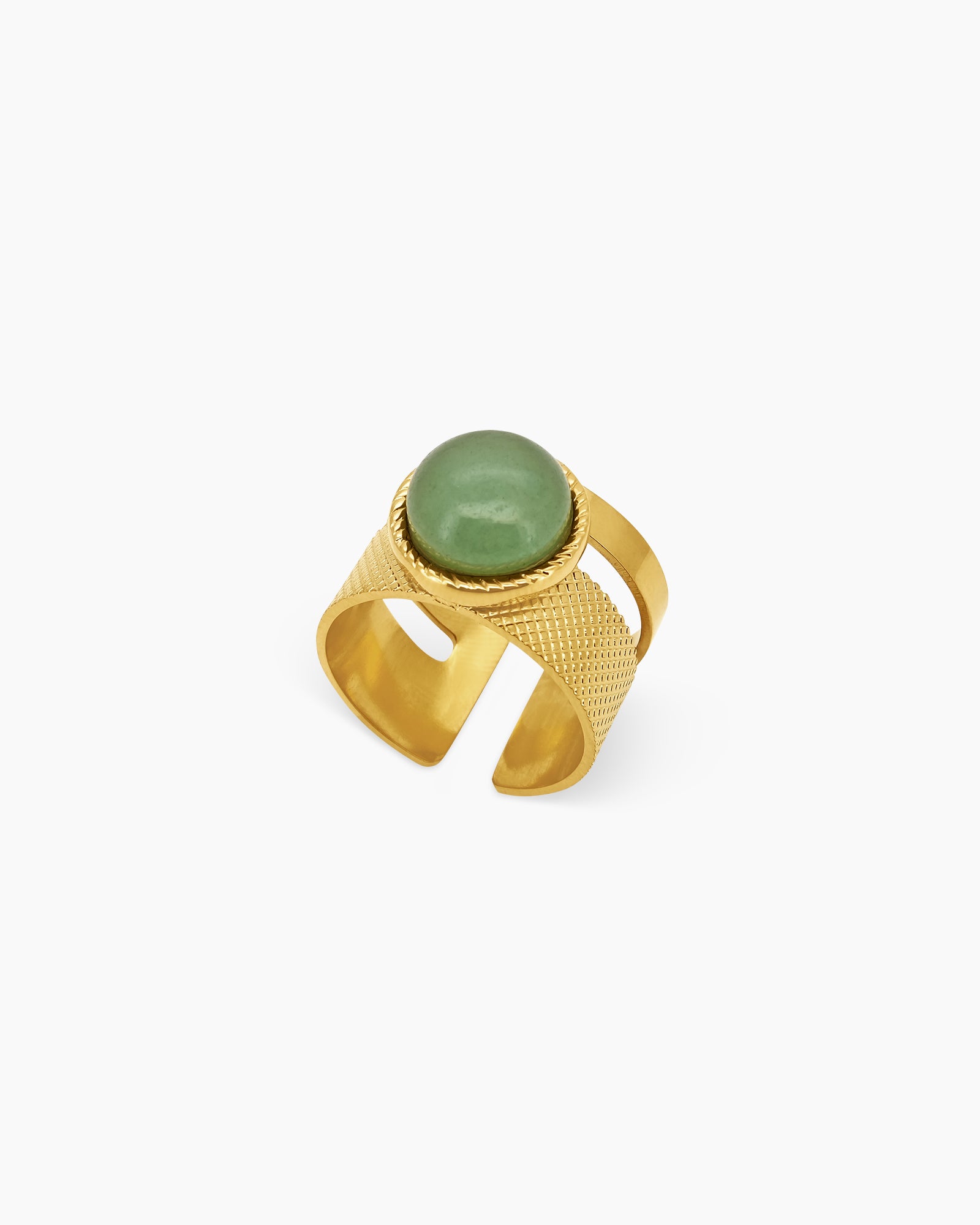 A ring with a soft green aventurine stone on a wide, gold-toned band etched with a subtle geometric pattern