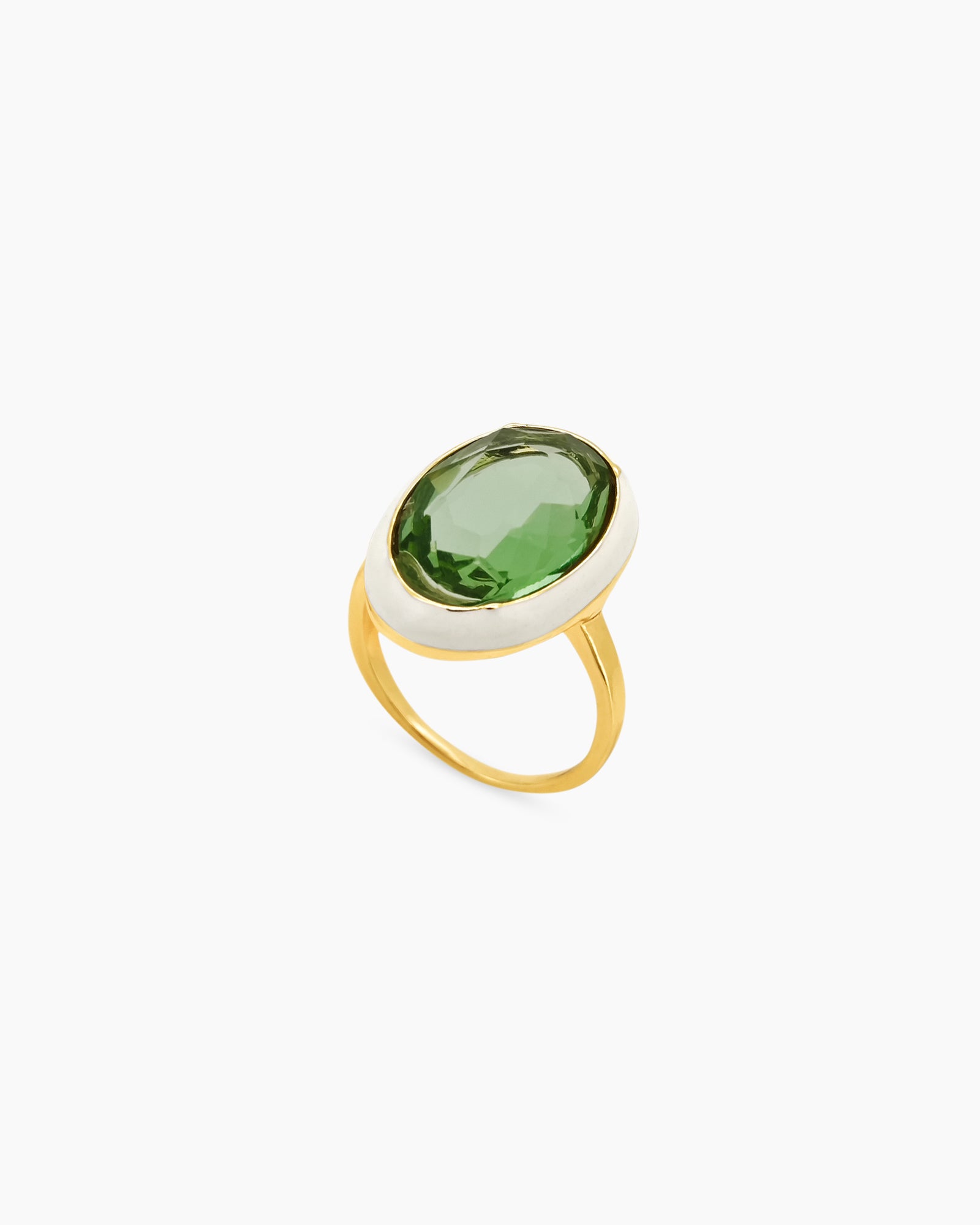 A green-white cocktail ring with a large, faceted oval stone framed by a glossy enamel halo on a gold band