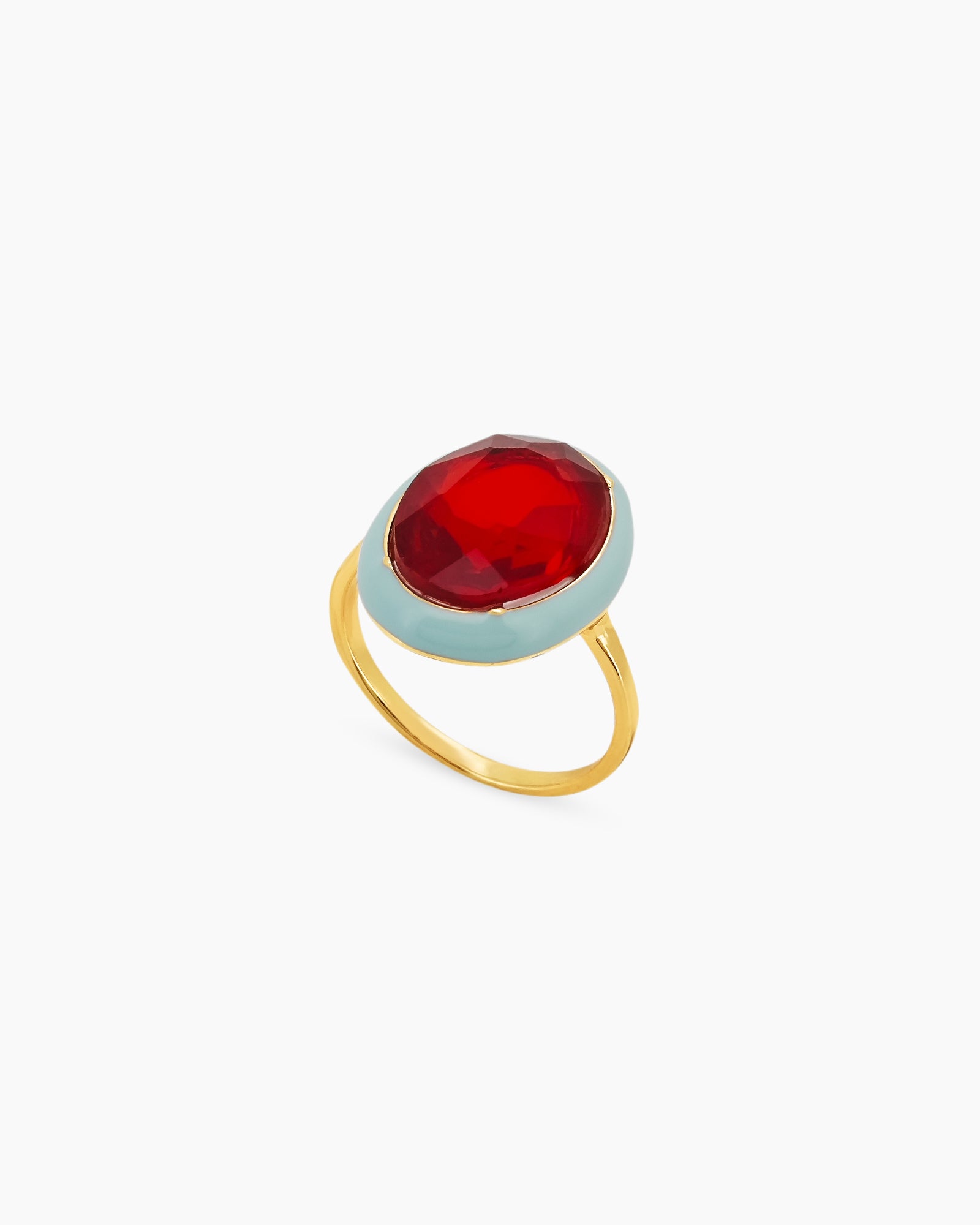 A red-blue cocktail ring with a large, faceted oval stone framed by a glossy enamel halo on a gold band