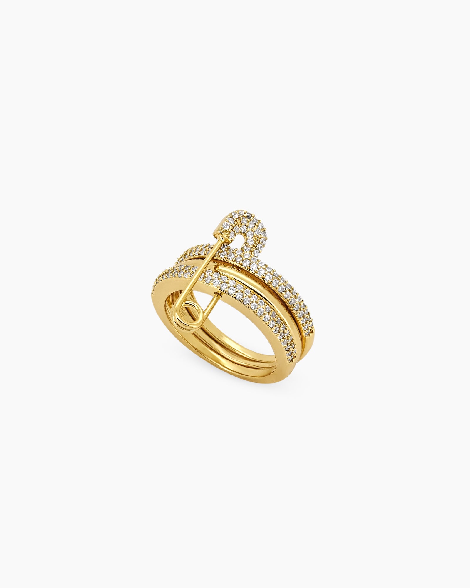A gold stacked band ring with a crystal-studded safety pin detail for a stylish, daring twist
