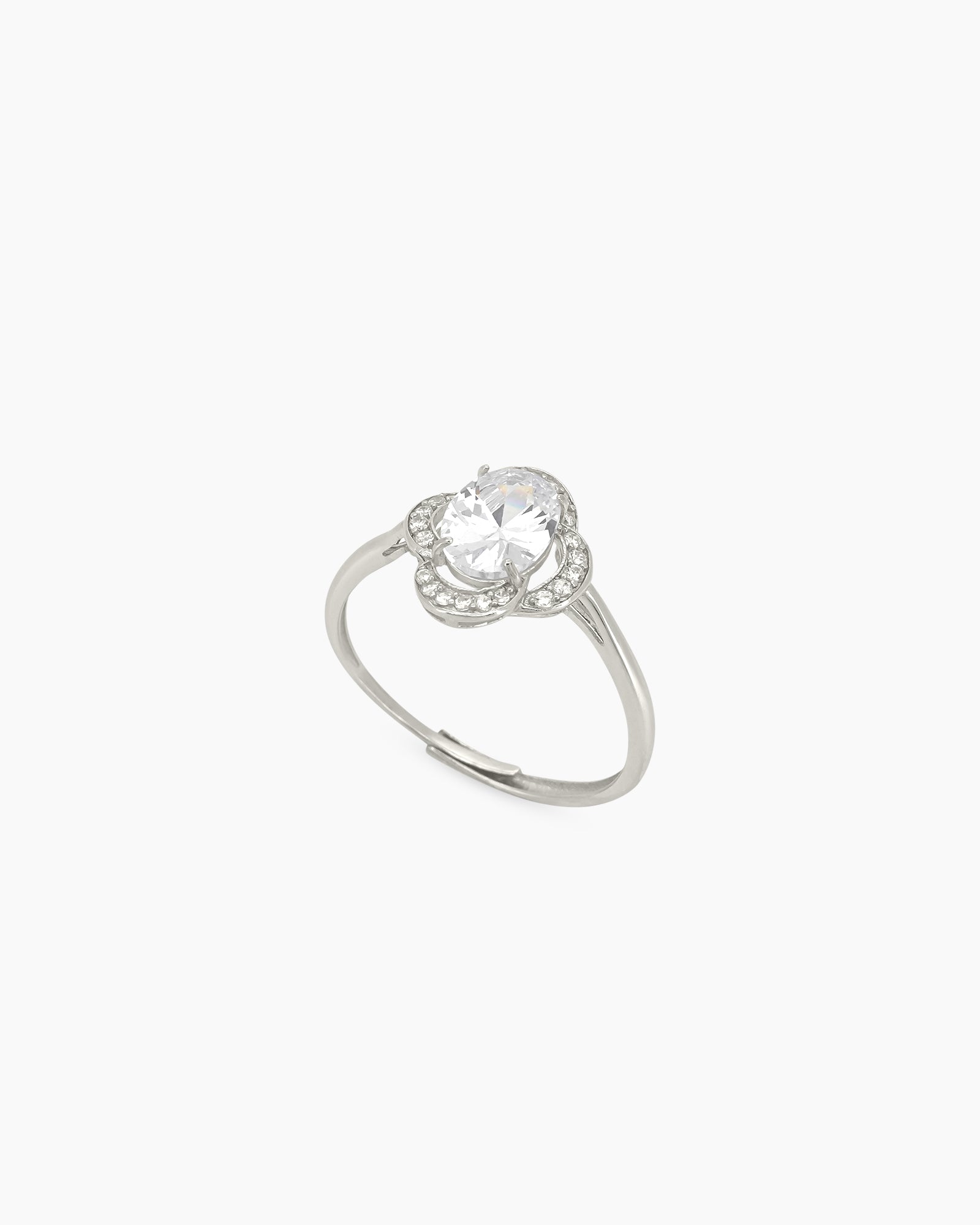 A ring with a brilliant oval-cut white zircon and a halo of tiny round stones in a clover-like silhouette
