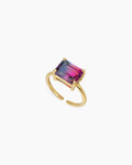 A blue-to-rose-red ring with an emerald-cut ombré zircon that shifts in the light, on a sleek open band