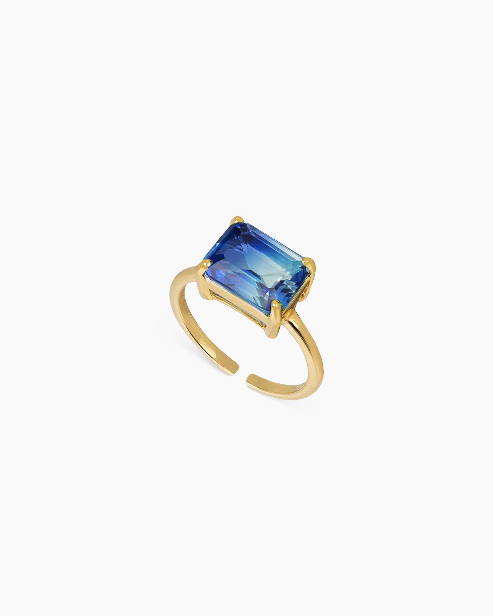 A light-to-dark-blue ring with an emerald-cut ombré zircon that shifts in the light, on a sleek open band