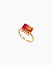 A light-to-dark-orange ring with an emerald-cut ombré zircon that shifts in the light, on a sleek open band