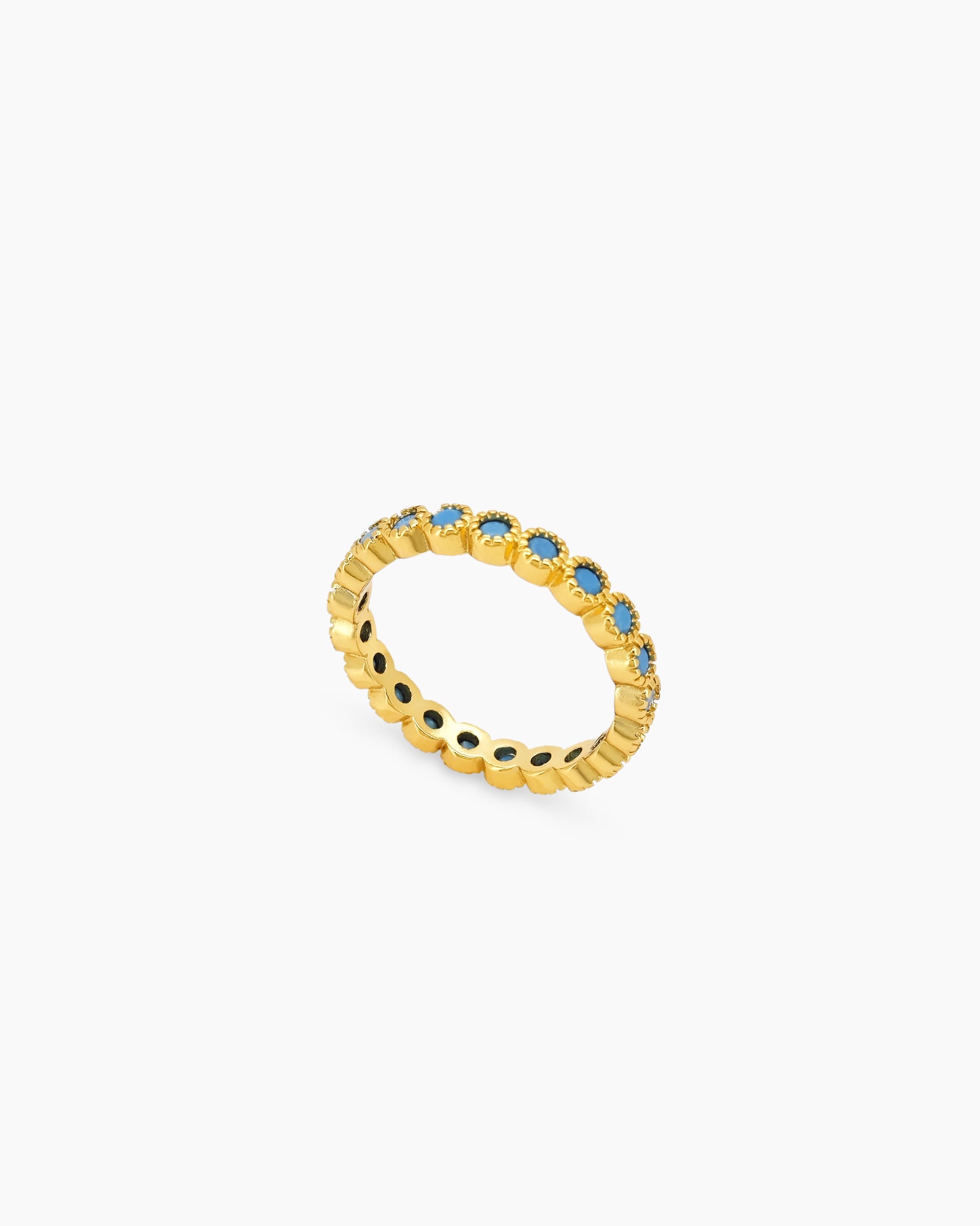 A band ring with a full circle of vivid turquoise stones set in textured gold-tone bezels
