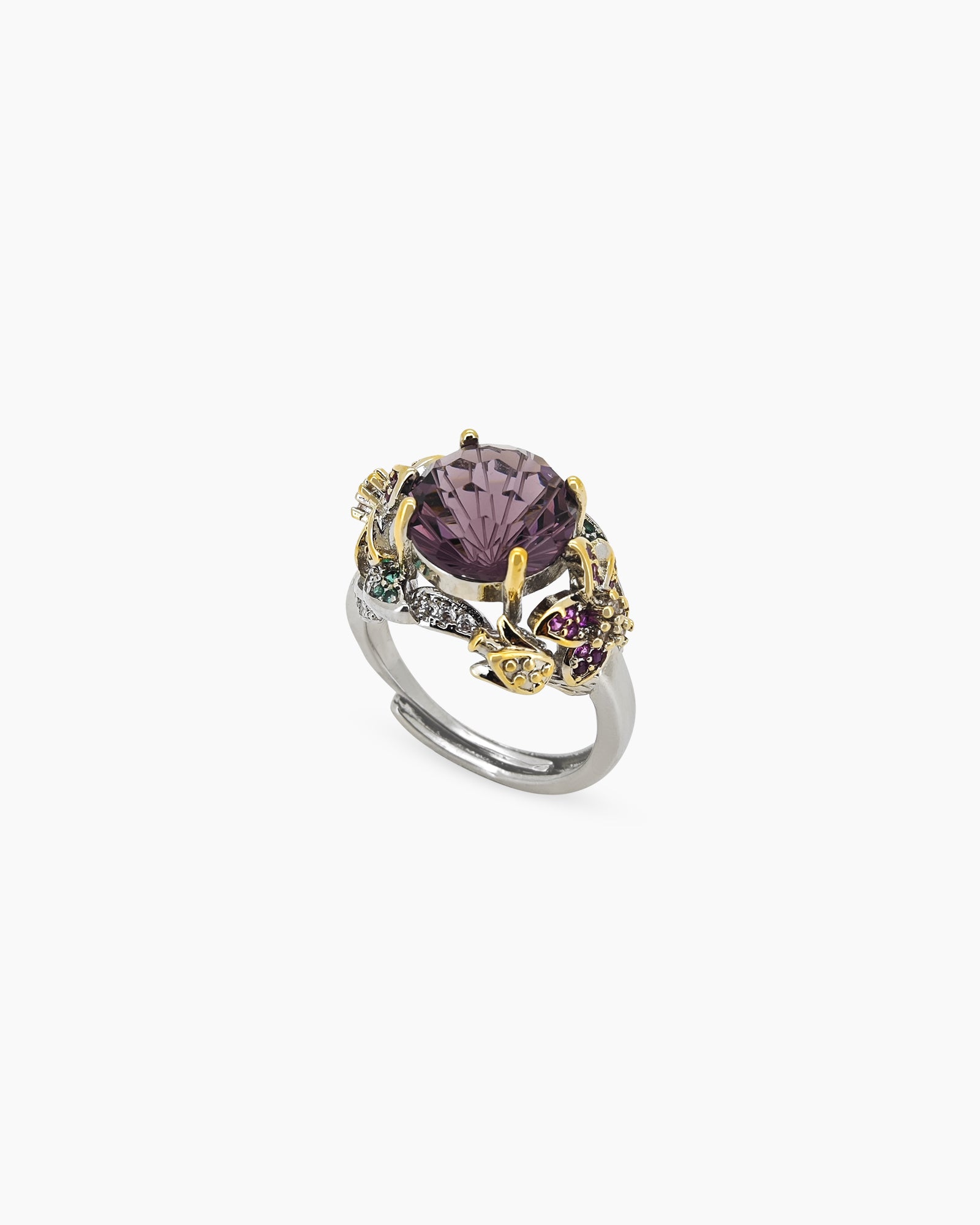 A cocktail ring with a majestic violet crystal, jeweled butterflies, and leaves on a mixed-metal band