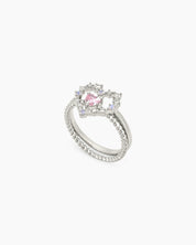 A ring set with a delicate open-heart silhouette and a sparkling pink heart stone for a magical look