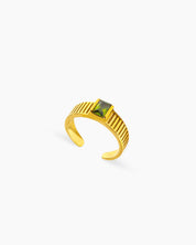An adjustable gold ring with a deep green zircon and vertical grooves along the band for a vintage mood