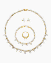 A jewelry set with a collar necklace, bracelet, earrings, and ring, all in gleaming gold tones