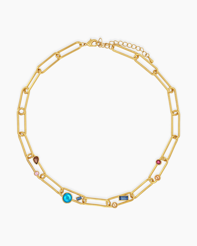 A necklace of oversized gold-tone paperclip links, adorned with an array of multicolored crystal stones