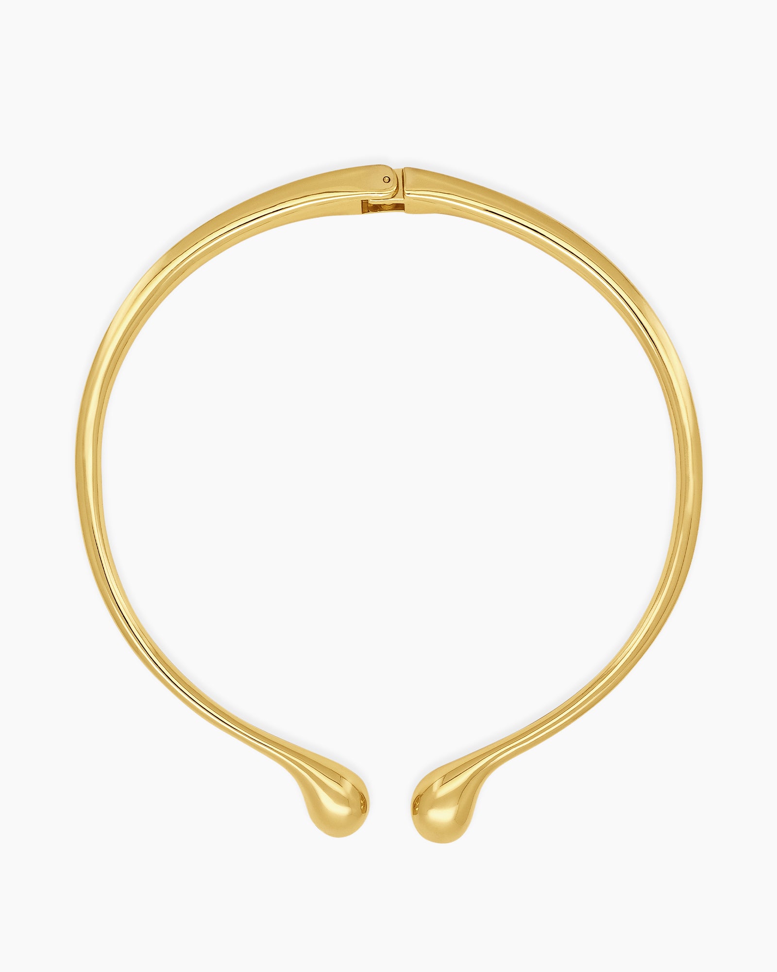 A polished gold necklace featuring a clean, narrow torque design with smooth, droplet-like tips