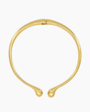A polished gold necklace featuring a clean, narrow torque design with smooth, droplet-like tips
