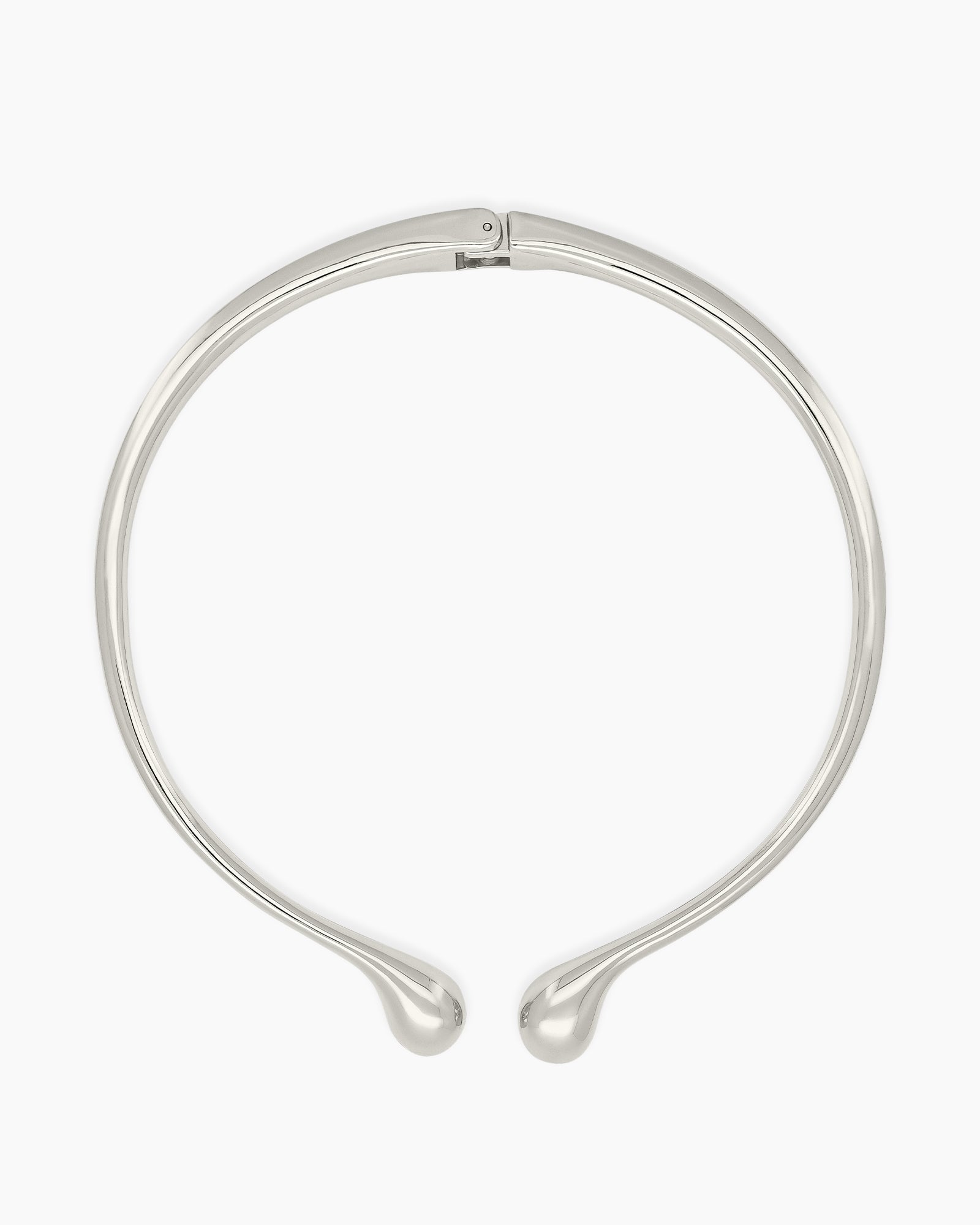 A polished silver necklace featuring a clean, narrow torque design with smooth, droplet-like tips