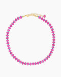A beaded necklace with glossy fuchsia-toned quartz beads and petite turquoise-blue spacers
