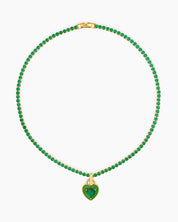 A green tennis necklace with a full strand of zircon stones and an enamel heart charm with a center stone