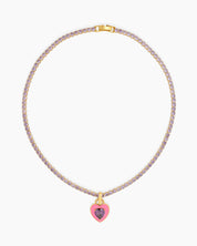 A light-pink tennis necklace with a full strand of zircon stones and an enamel heart charm with a center stone