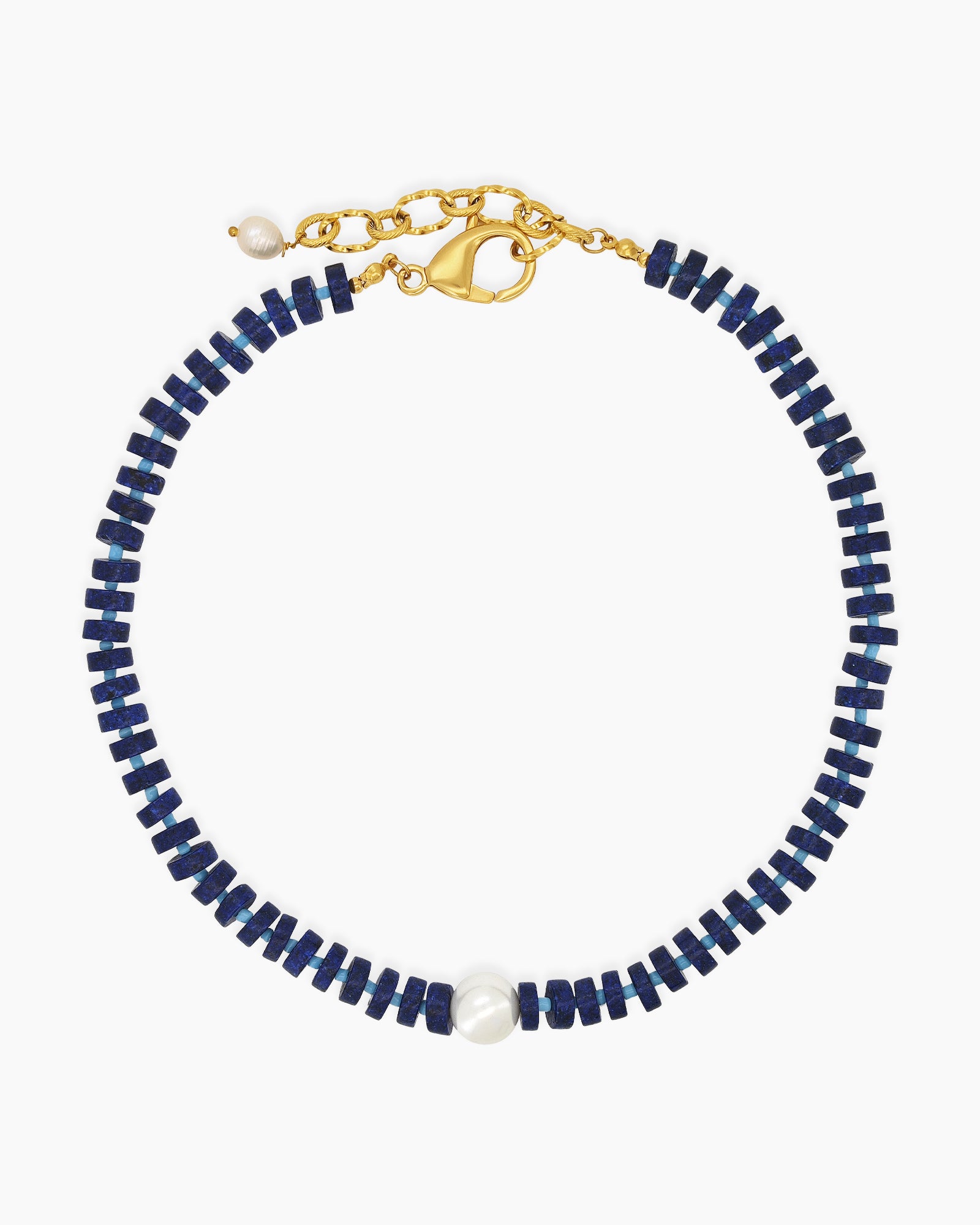 A sleek, structured necklace of navy-blue lapis lazuli beads with a glossy freshwater pearl at its heart