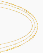 A gold waist chain with two sleek layers, one dotted with tiny beads and the other with shimmering discs