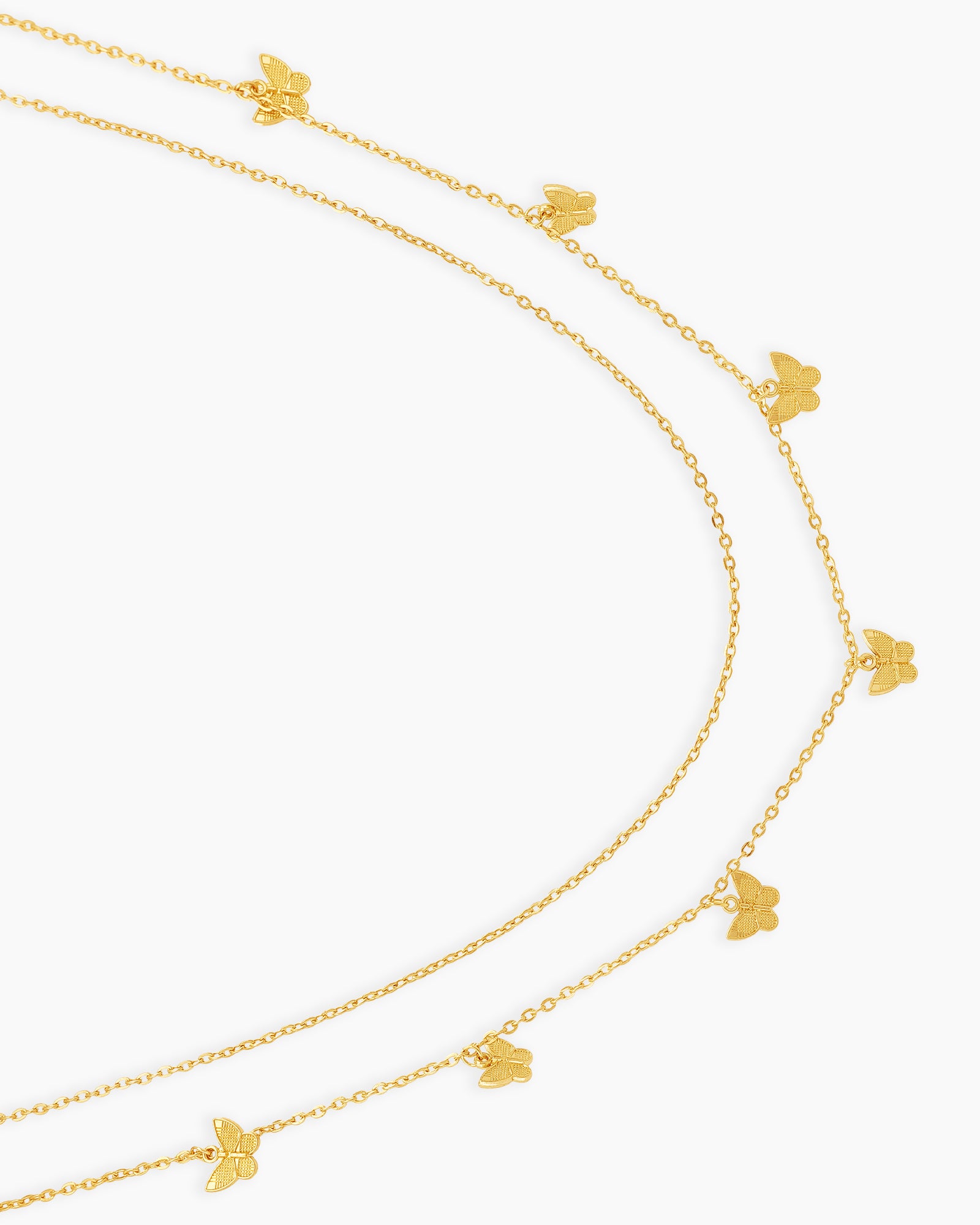 A gold waist chain with two layered strands adorned with dainty butterfly charms for a carefree spirit