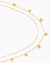 A gold waist chain with two layered strands adorned with dainty butterfly charms for a carefree spirit