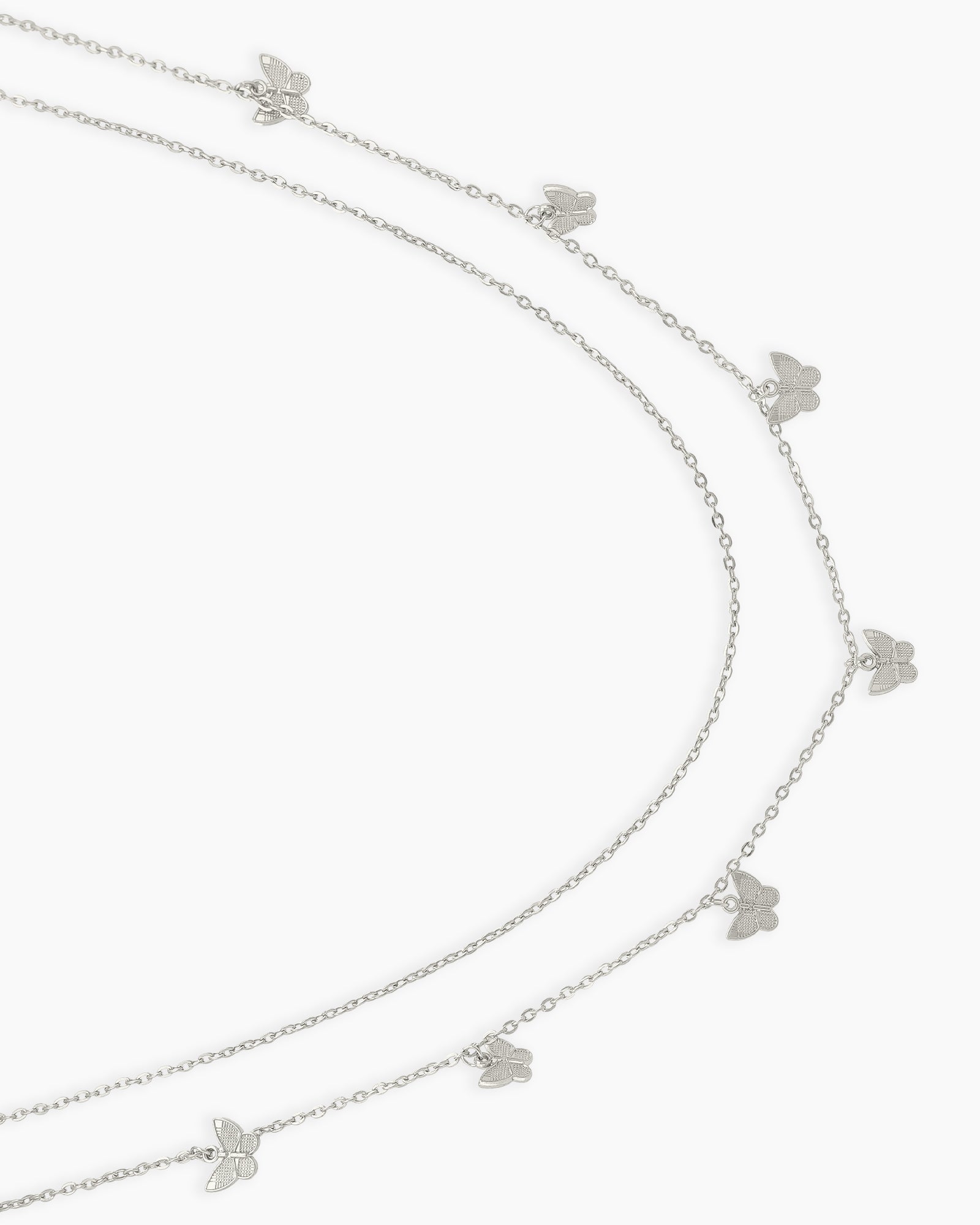 A silver waist chain with two layered strands adorned with dainty butterfly charms for a carefree spirit