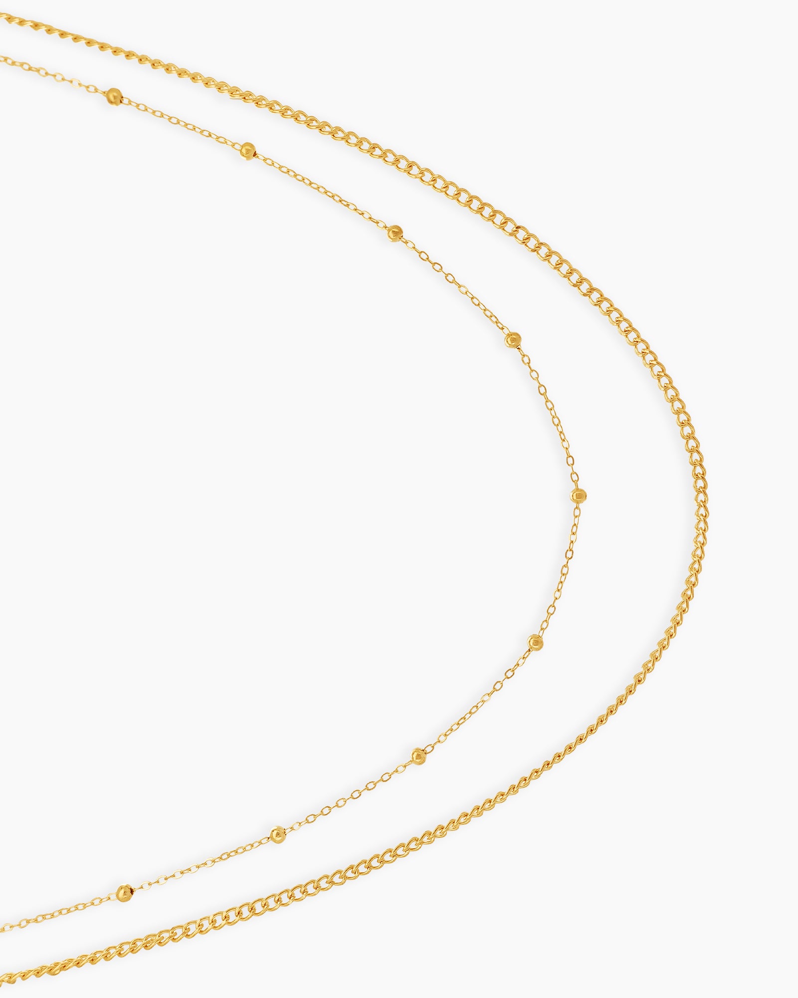 A double-layered gold waist chain with one sleek and one delicately dotted strand for a minimal, chic look