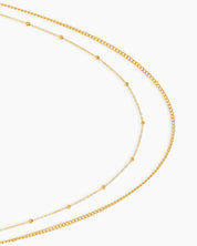 A double-layered gold waist chain with one sleek and one delicately dotted strand for a minimal, chic look