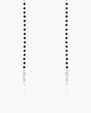 A minimalist glasses chain with tiny faceted black beads along a fine silver-tone chain