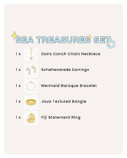 A collection of pearl, conch, and textured gold accessories for a look of pure coastal elegance