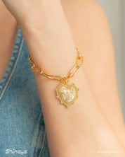 A paperclip chain bracelet with a radiant, textured heart pendant engraved with the word "love"