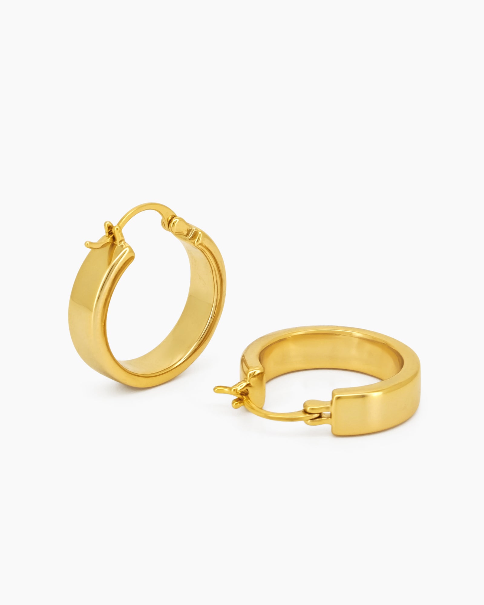 Chunky, rounded gold hoop earrings with clean lines and a hinged latch back for a confident look