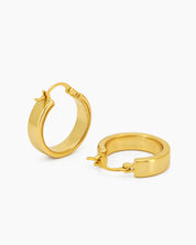 Chunky, rounded gold hoop earrings with clean lines and a hinged latch back for a confident look