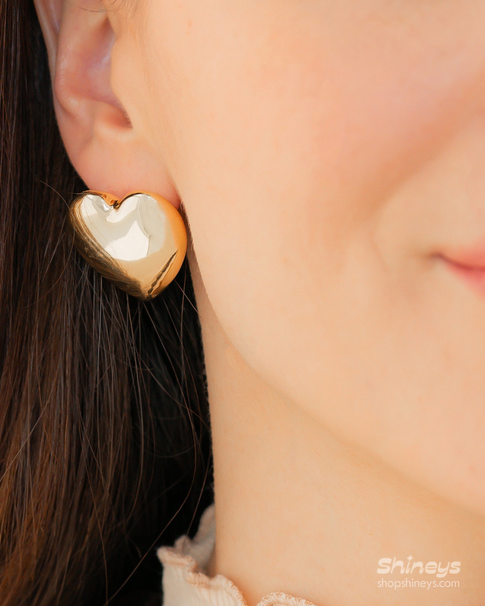 Puffed heart stud earrings with a smooth, softly rounded silhouette and a modern, glossy gold-tone finish