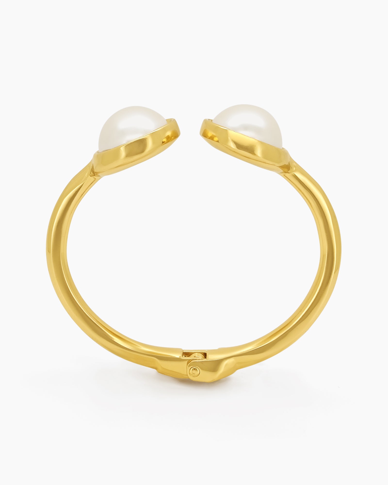 A polished gold cuff with two oversized faux pearls in a glossy frame and a secure hinge closure