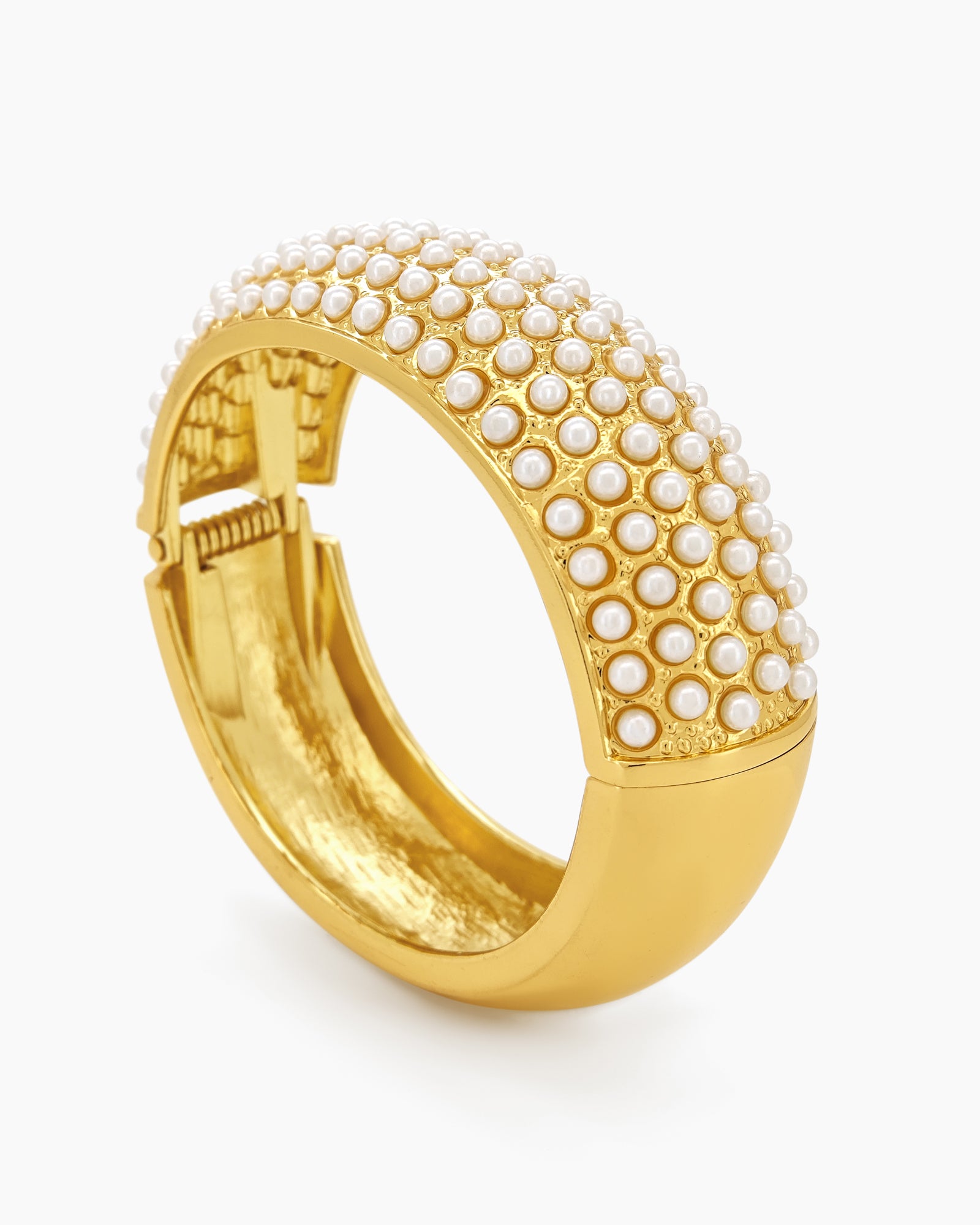 A gold-tone bangle encrusted with rows of tiny faux pearls, creating a soft, sculptural rhythm
