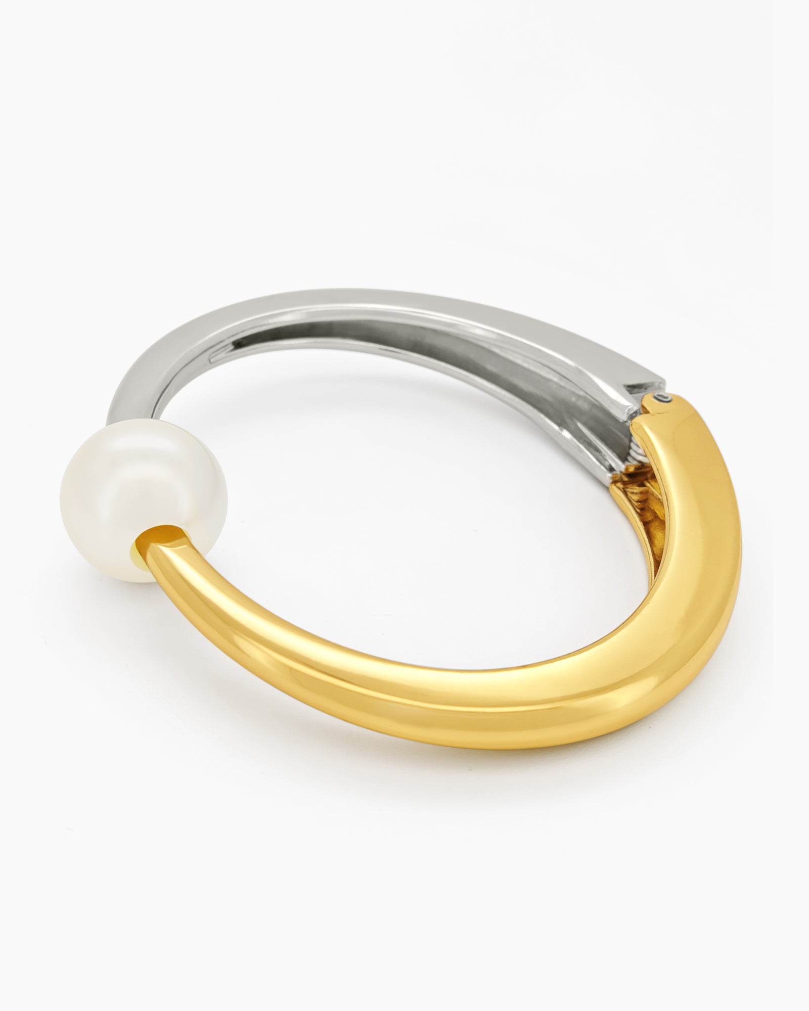 A mixed-metal hinged bangle pairing silver and gold in a seamless line, with a single pearl accent
