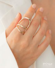 A sleek gold ring with a fluid, open curve and a high-shine finish for a modern, sculptural look