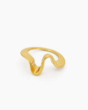 A golden ring with a curvy, freeform shape that shines with a polished, playful glow