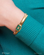 A green bracelet with a bold gold-tone snake chain and a rectangular malachite charm