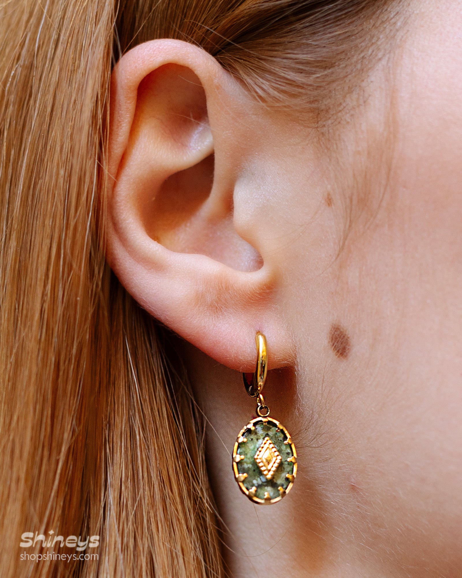 Earrings that pair lush green african pine stones with golden bezel detailing for a vintage look