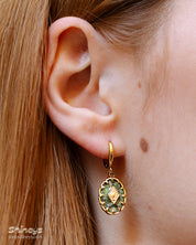 Earrings that pair lush green african pine stones with golden bezel detailing for a vintage look