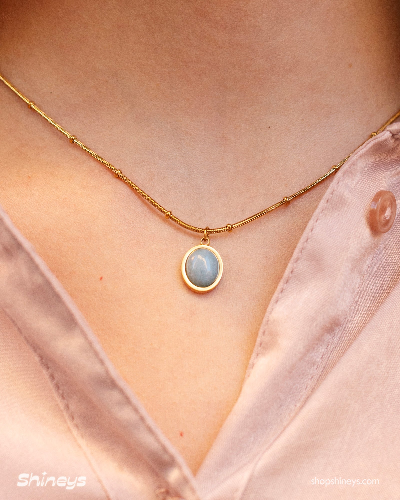 A necklace with an oval-cut cat eye stone on a vintage-inspired satellite chain for a romantic look