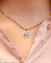 A necklace with an oval-cut cat eye stone on a vintage-inspired satellite chain for a romantic look