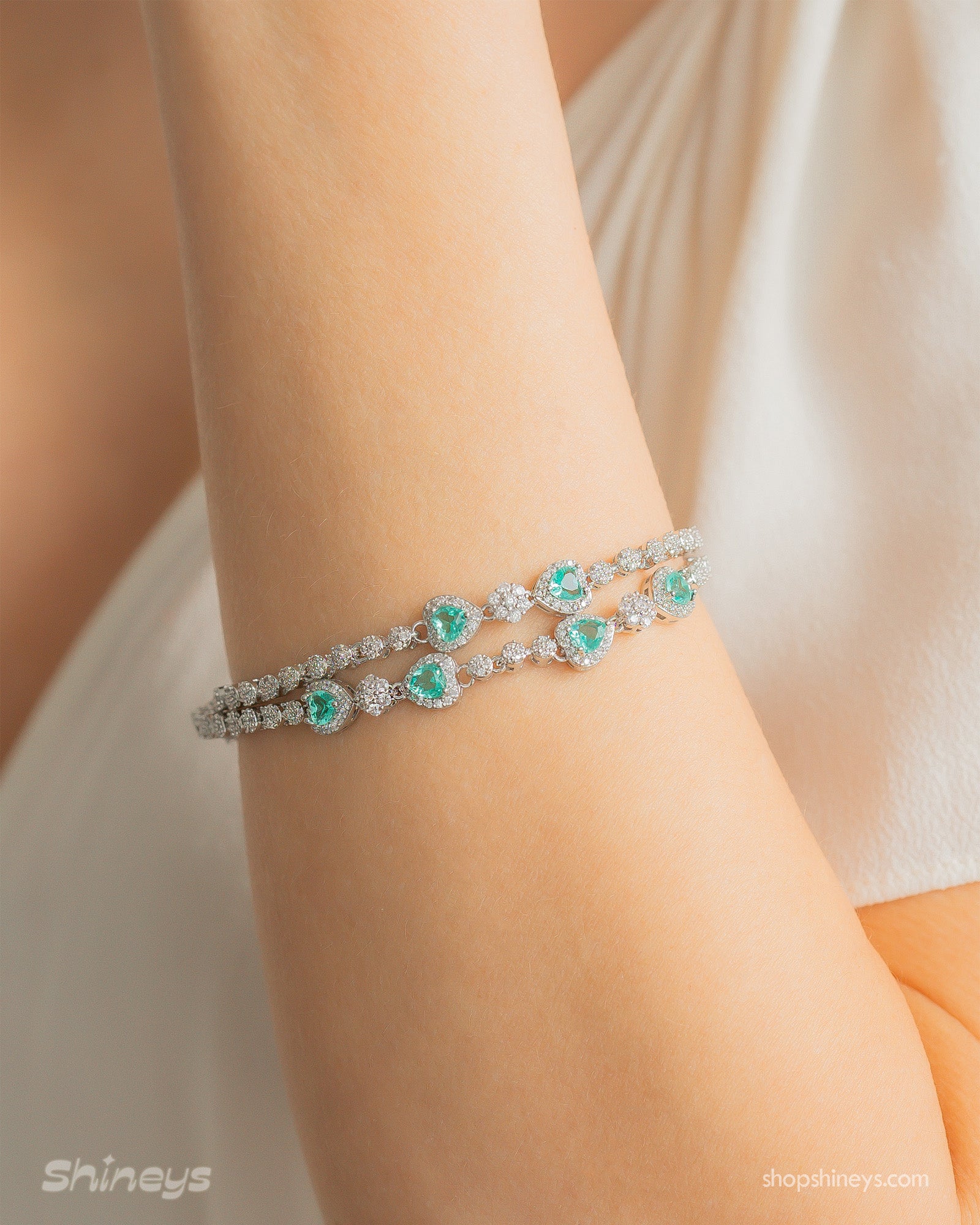 A radiant lake-blue vintage-style bracelet with two rows of zircons and five haloed heart-shaped centerpieces