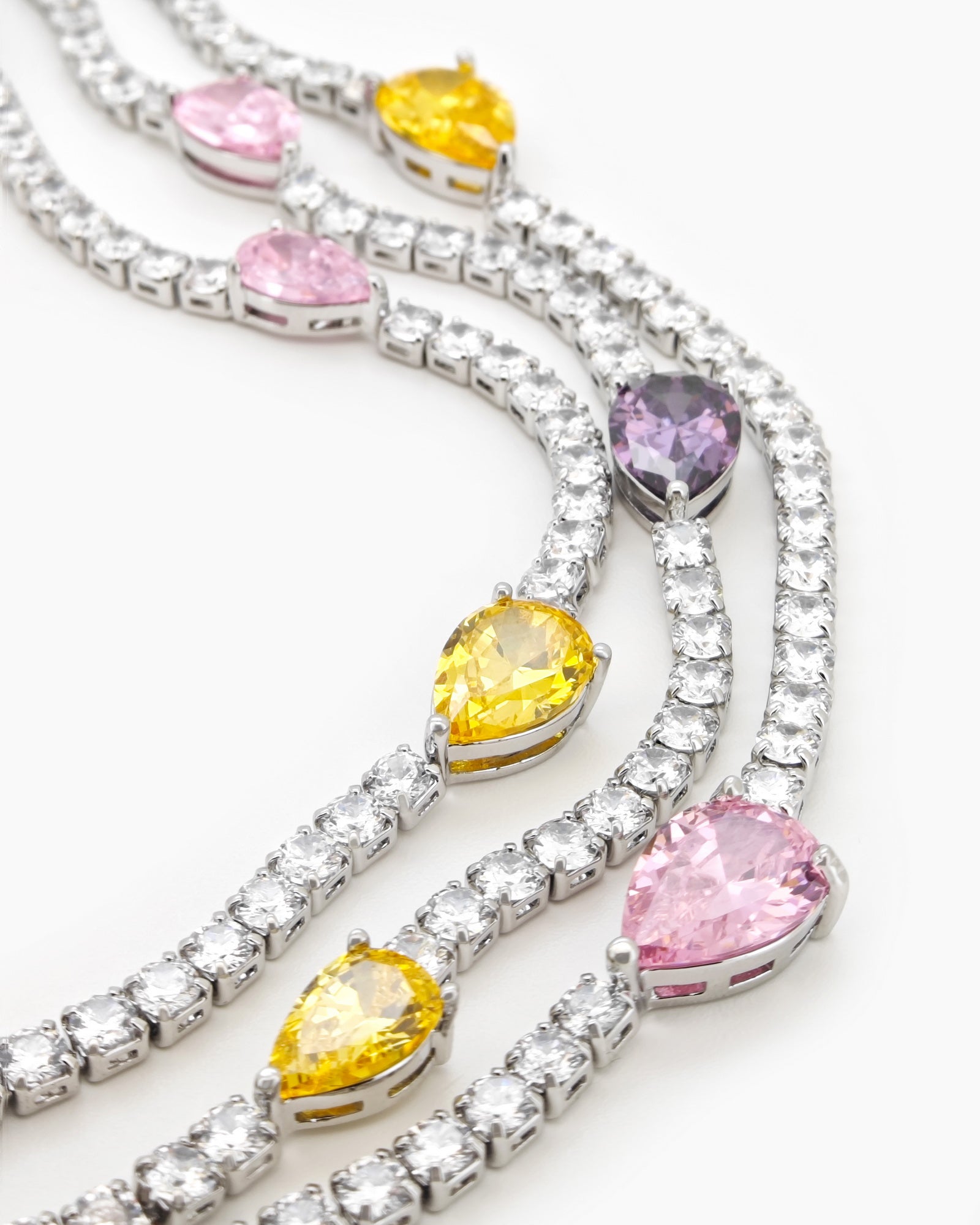 A set with a cascade of three crystal rows, teardrop-shaped zircon stones, and coordinating earrings