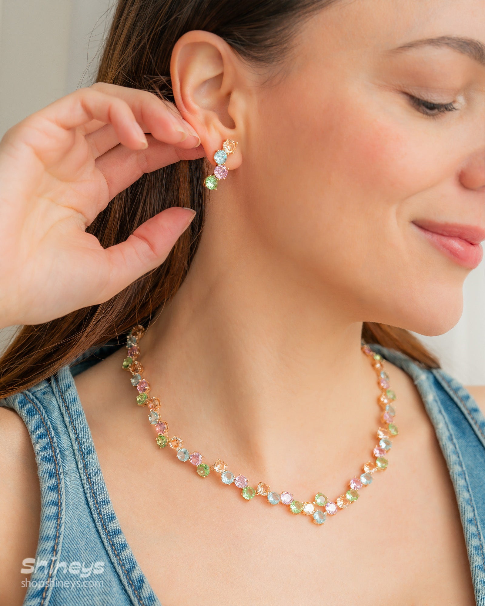 A set with a collar-style necklace and drop earrings, adorned with a playful array of pastel zircon stones
