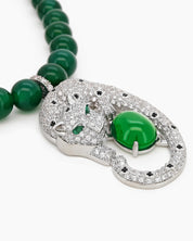 A necklace with a full strand of deep green jade beads and a striking silver-tone panther pendant