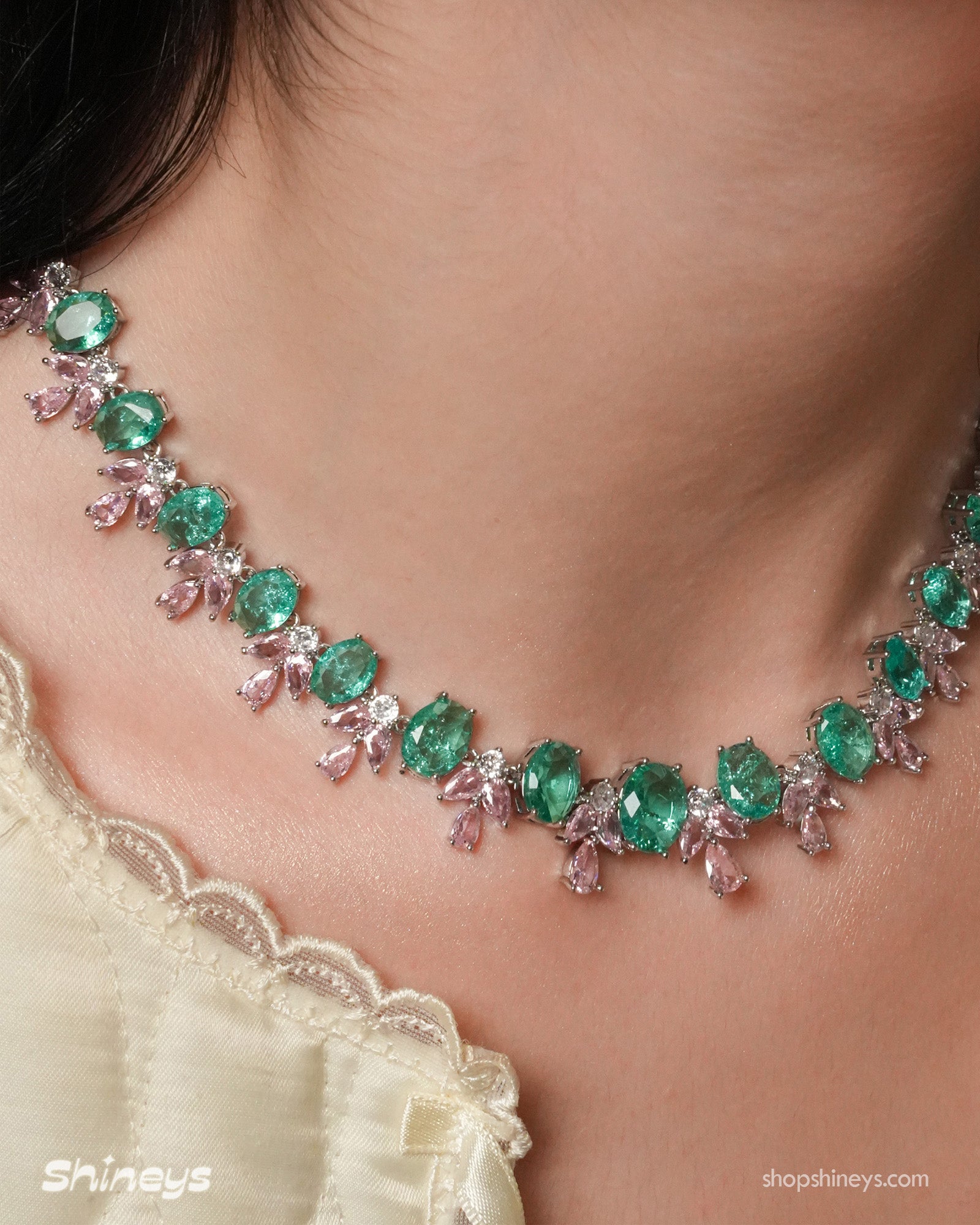 A jewelry set with radiant green oval zircons flanked by whimsical pink and white gemstone accents