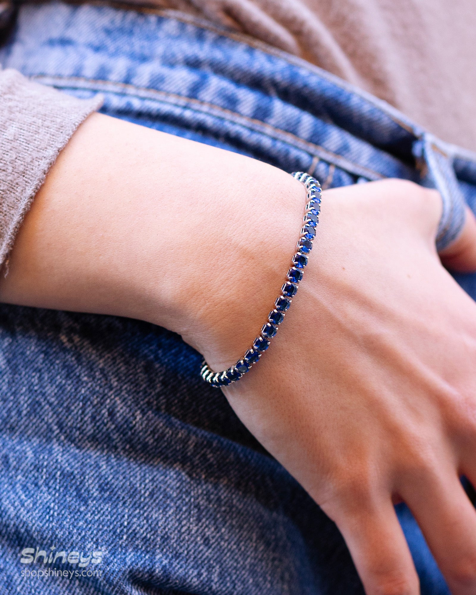 A classic tennis bracelet featuring vibrant, round-cut navy zircon stones in a sleek silver-tone channel