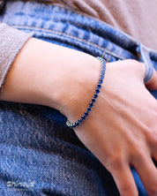 A classic tennis bracelet featuring vibrant, round-cut navy zircon stones in a sleek silver-tone channel